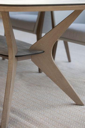 Close-up of wooden table legs with a modern, angular design on a light, textured carpet.
